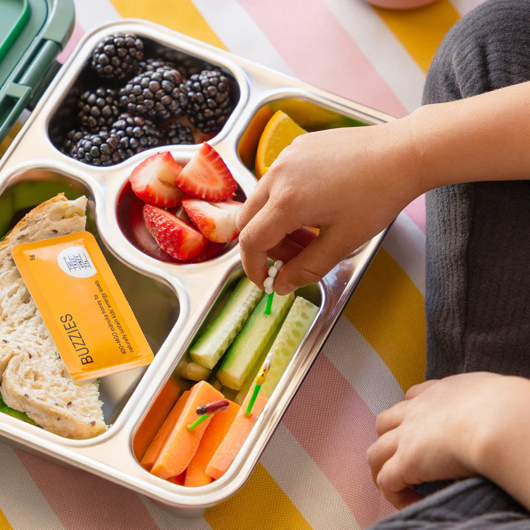 Lunchboks et honningbrev og friske frugter, grøntsager og brød