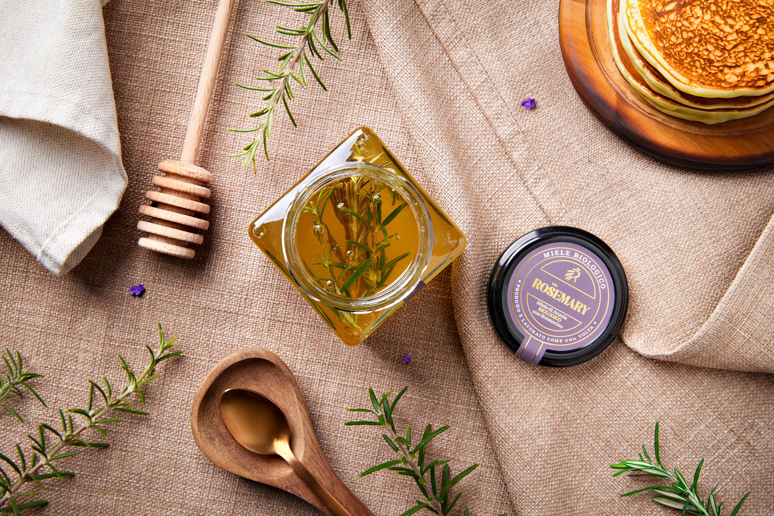 Opstilling på dug med glas med rosmarin honning og pandekager, fra Italien