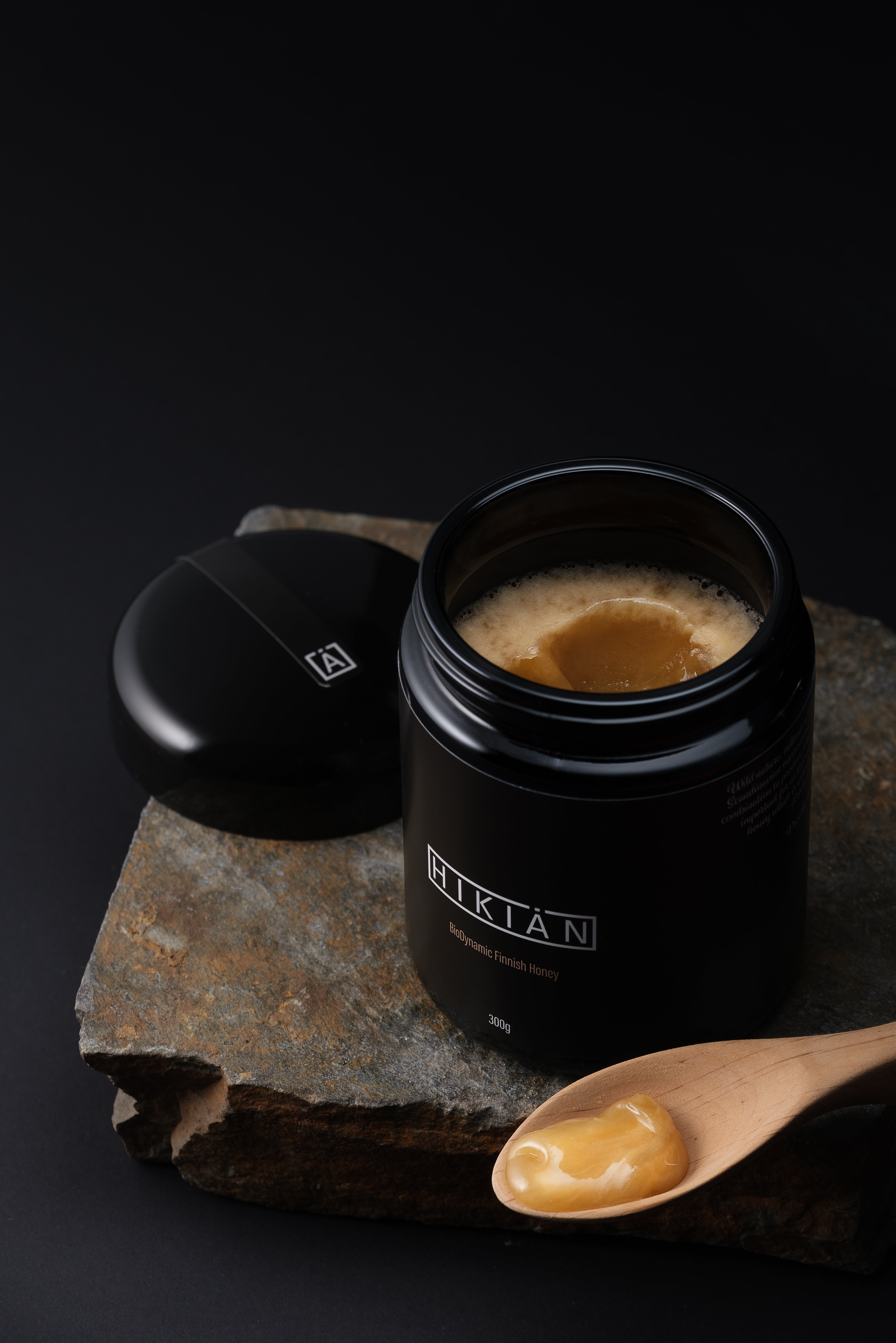 sjælden og exceptionel Hikiän – finsk honning i sin reneste form, i ekslusiv sort glas, på et bord. 