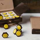 Alemany Chokoladesekskanter med honningfyld – 18 stk i æske på et bord med stykker der ligger på bordet