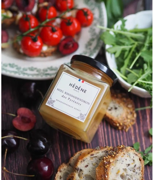 Glas med Hédéne Rhodondendron des Pyrénées honning, på bord med frugt - grønt og brød,  Frankrig
